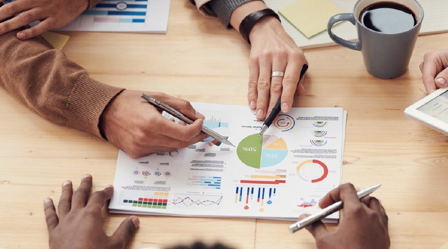 People In A Meeting Looking Over Chart Data
