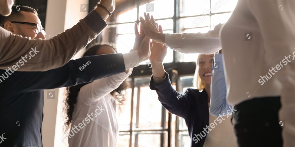Group Of Employees High-fiving Demonstrating Collaboration
