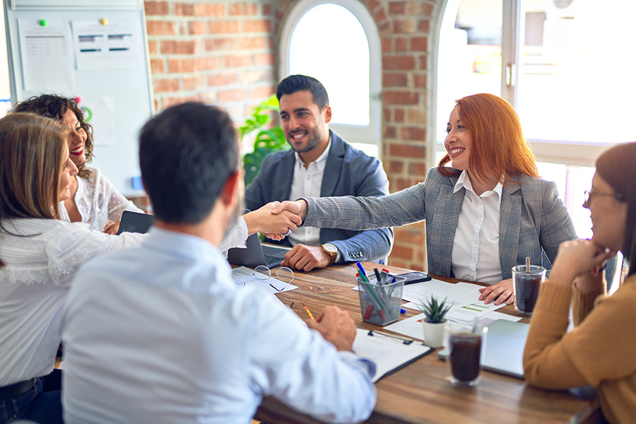 Two employees shaking hands in a business meeting